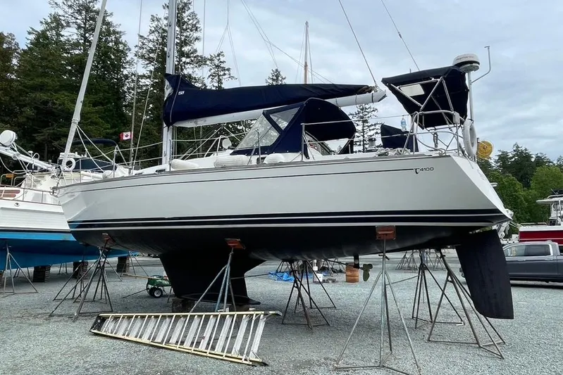 "snapdragon" Yacht Photos Pics Sailboat Tartan 4100, 1999 model, on stands in a marina with trees in the background.