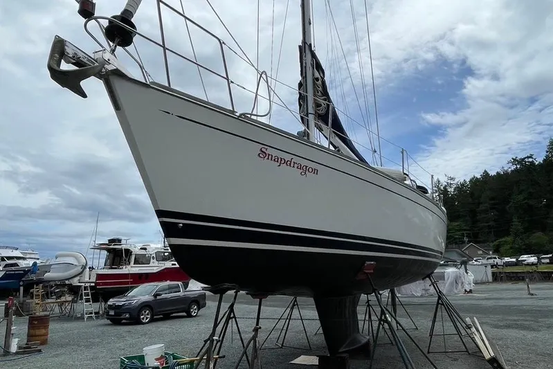 "snapdragon" Yacht Photos Pics 1999 Tartan 4100 sailboat "Snapdragon" on stands in a boatyard, cloudy sky background.