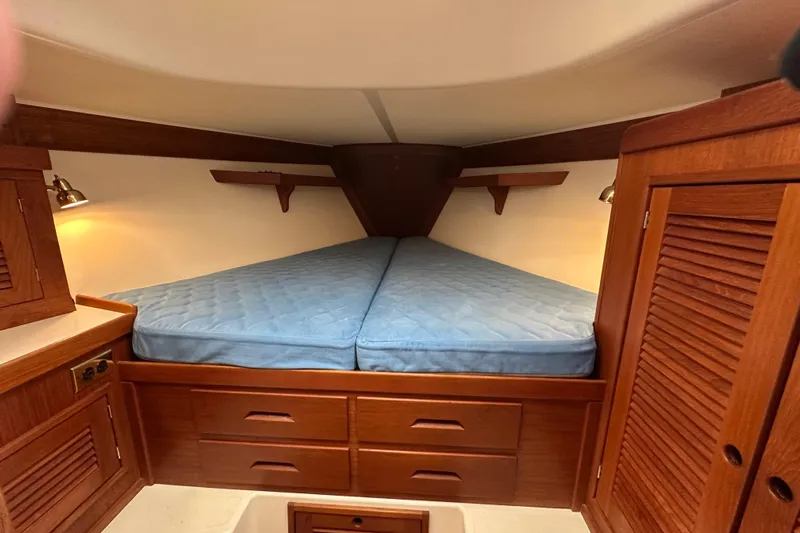 "snapdragon" Yacht Photos Pics Cozy cabin interior of 1999 Tartan 4100 sailboat with wooden furnishings and blue mattress.