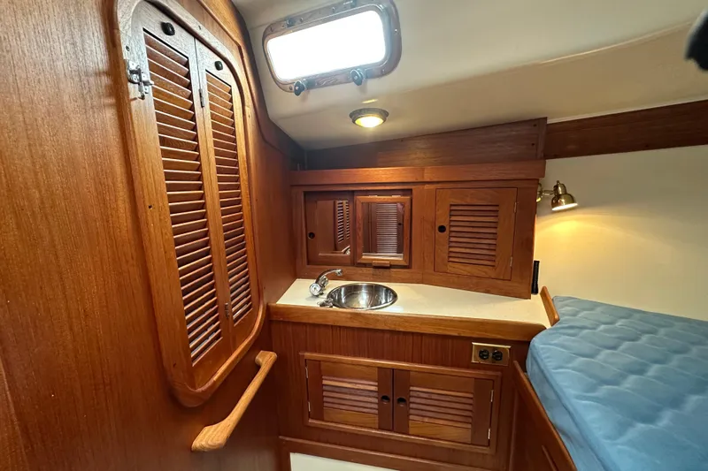 "snapdragon" Yacht Photos Pics Cozy 1999 Tartan 4100 yacht cabin with wooden cabinetry and compact sink.