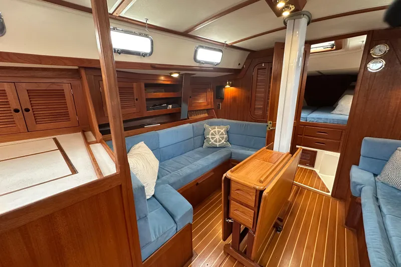 "snapdragon" Yacht Photos Pics Interior of 1999 Tartan 4100 sailboat with blue seating and wooden finishes.