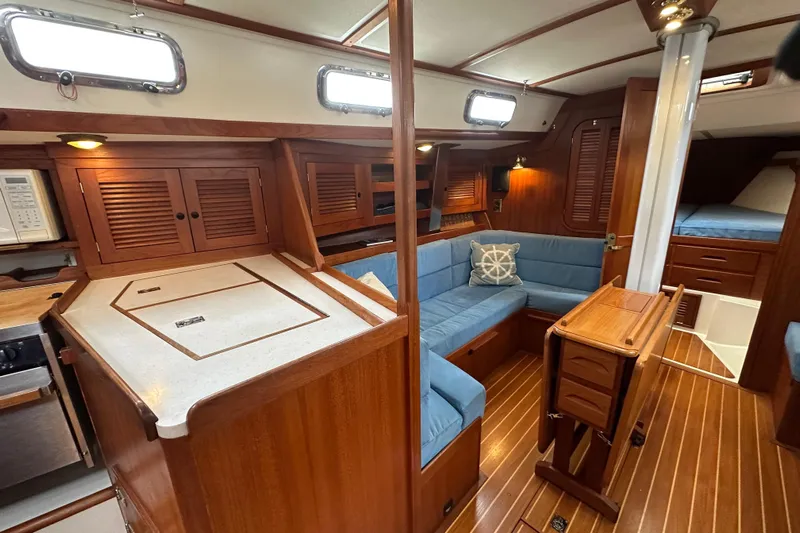 "snapdragon" Yacht Photos Pics Interior of a 1999 Tartan 4100 sailboat with wood finish and blue seating.