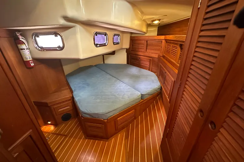 "snapdragon" Yacht Photos Pics Cozy cabin interior of 1999 Tartan 4100 sailboat with wooden furnishings and portholes.