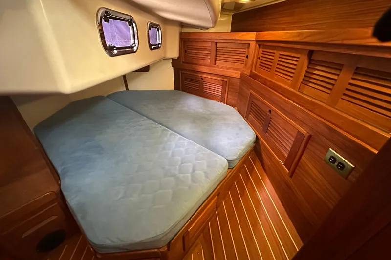 "snapdragon" Yacht Photos Pics Cozy cabin interior of 1999 Tartan 4100 sailboat with wooden paneling and blue mattress.