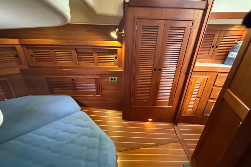 "snapdragon" Yacht Photos Pics 1999 Tartan 4100 yacht interior with wooden cabinetry and blue bedding.