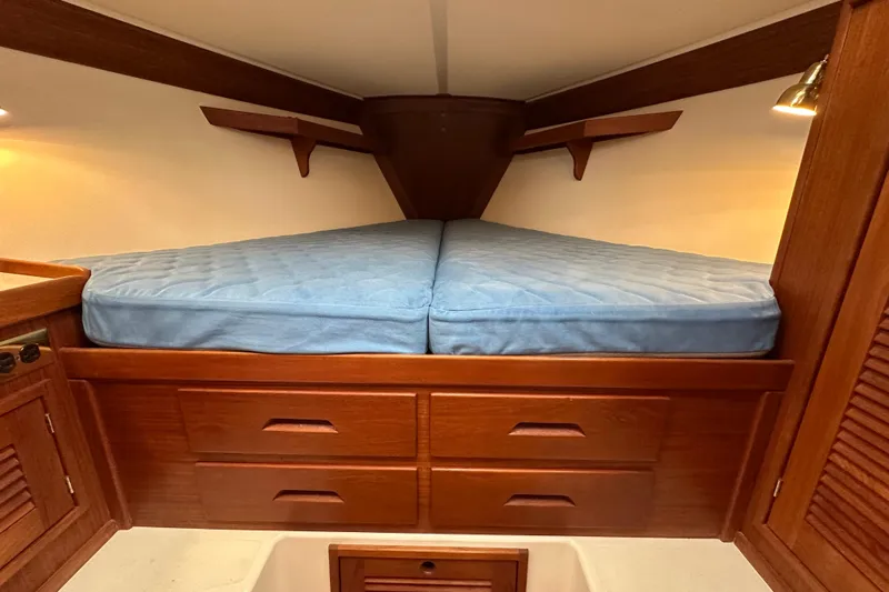 "snapdragon" Yacht Photos Pics Cozy cabin interior of 1999 Tartan 4100 sailboat with blue mattress and wooden storage.