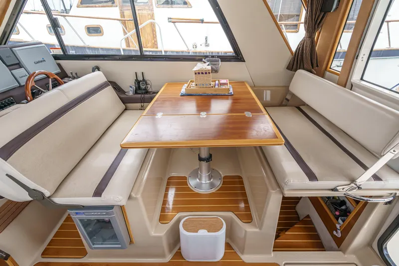 C-worthy III Yacht Photos Pics Interior of 2014 Cutwater C-30 SC LE boat with dining area and wooden table.