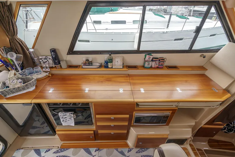C-worthy III Yacht Photos Pics 2014 Cutwater C-30 SC LE interior with wooden cabinetry and kitchen appliances.