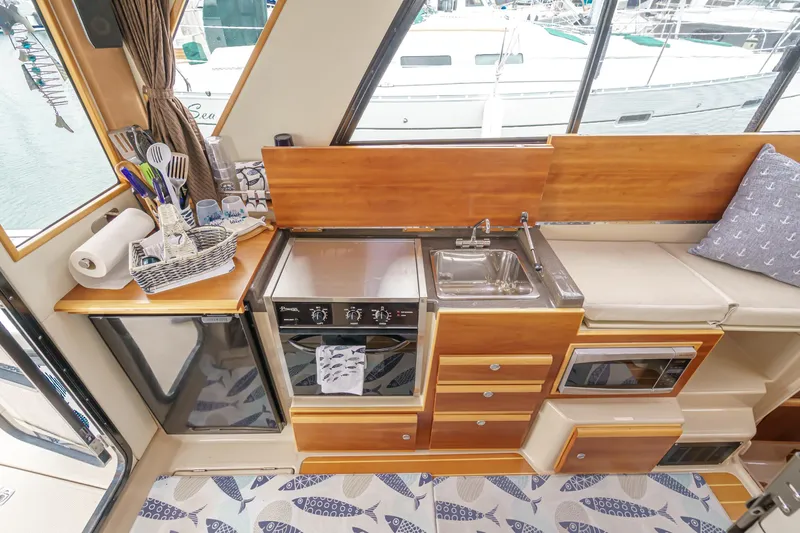 C-worthy III Yacht Photos Pics Compact kitchen in 2014 Cutwater C-30 SC LE boat with stove, sink, and storage.