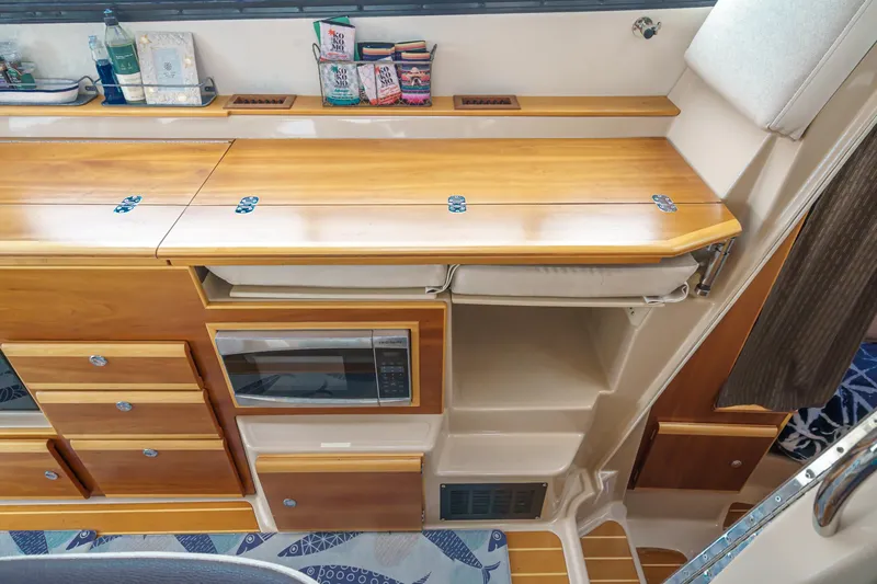 C-worthy III Yacht Photos Pics Interior of 2014 Cutwater C-30 SC LE boat with wooden cabinetry and built-in microwave.