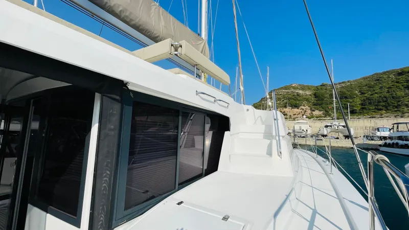  Yacht Photos Pics 2022 Bali 4.4 yacht docked in a scenic marina with clear blue skies.