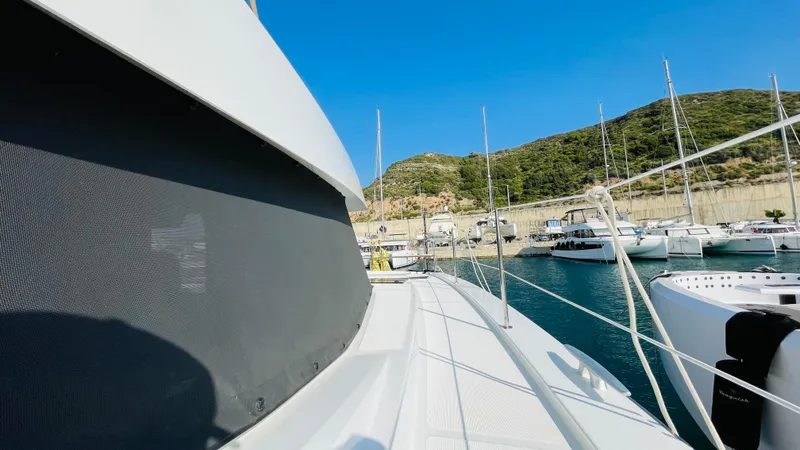  Yacht Photos Pics Bali 4.4 yacht docked in a scenic marina with hills in the background.