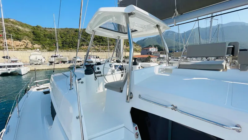  Yacht Photos Pics 2022 Bali 4.4 yacht cockpit with steering wheel, docked in a scenic marina.