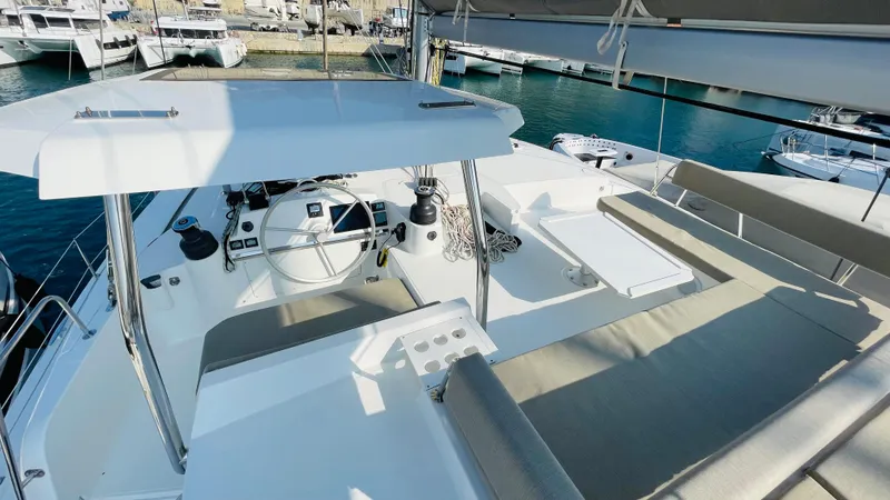  Yacht Photos Pics Modern Bali 4.4 yacht cockpit, 2022 model, featuring steering wheel and seating, docked at marina.