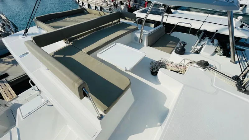  Yacht Photos Pics Luxurious Bali 4.4 catamaran deck with seating, table, and ropes, docked at marina, 2022 model.