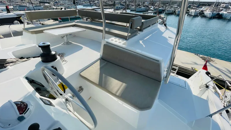  Yacht Photos Pics Modern Bali 4.4 yacht deck with seating, table, and steering wheel, docked at marina, 2022 model.