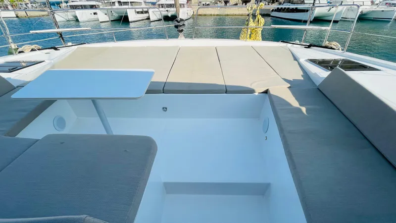  Yacht Photos Pics Spacious deck of 2022 Bali 4.4 yacht with seating and table, docked at marina.