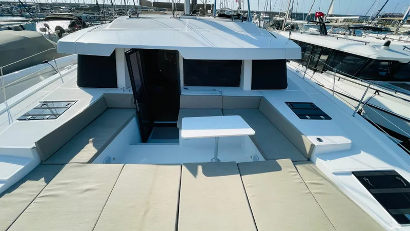  Yacht Photos Pics 2022 Bali 4.4 yacht deck with seating and table, docked at marina.