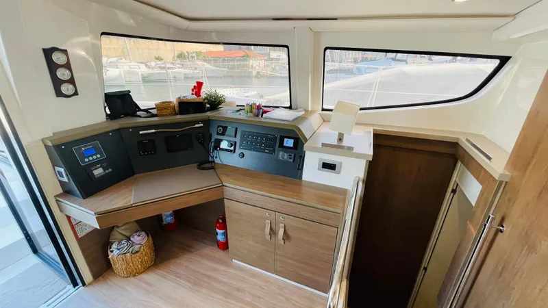  Yacht Photos Pics Interior of a 2022 Bali 4.4 yacht cockpit with navigation controls and wooden cabinetry.