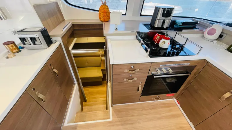  Yacht Photos Pics Modern kitchen interior on a 2022 Bali 4.4 yacht, featuring wood cabinets and appliances.