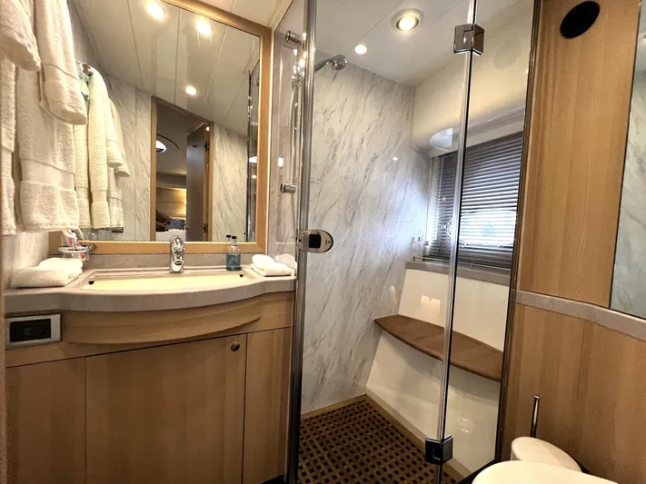  Yacht Photos Pics Luxurious bathroom in 2006 Princess V70 yacht with modern fixtures and elegant wood accents.
