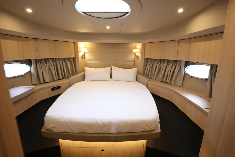  Yacht Photos Pics Luxurious cabin interior of 2006 Princess V70 yacht with cozy bed and elegant lighting.