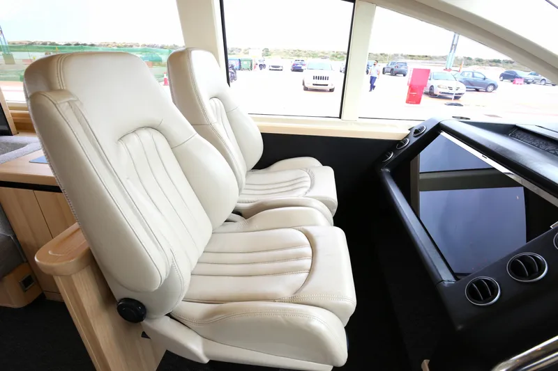  Yacht Photos Pics Luxurious interior of 2006 Princess V70 yacht with plush white seating and modern dashboard.