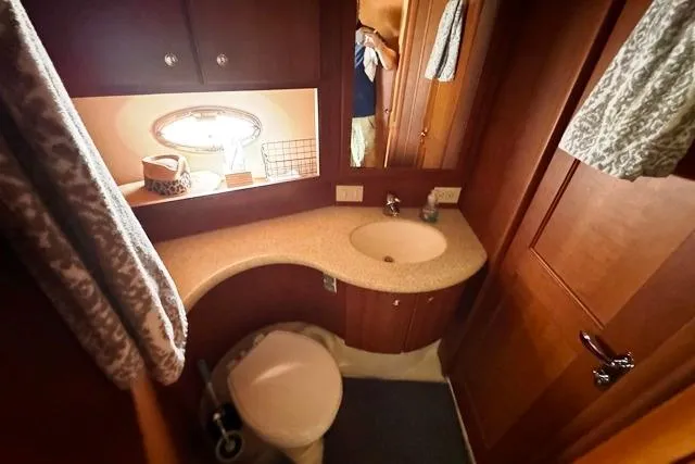  Yacht Photos Pics 2004 Silverton 35 MY Aft Cabin Motoryacht bathroom with sink, toilet, and wooden cabinetry.
