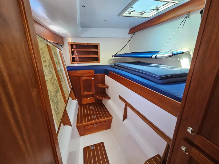 Audrey Louisa Yacht Photos Pics Interior cabin of 2012 Maine Cat Power Cat 47 with wooden finishes and blue bedding.