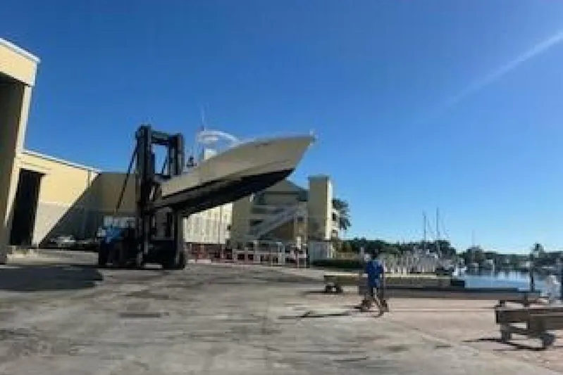  Yacht Photos Pics Forklift lifting 2019 OceanPro 35 boat near marina under clear blue sky.
