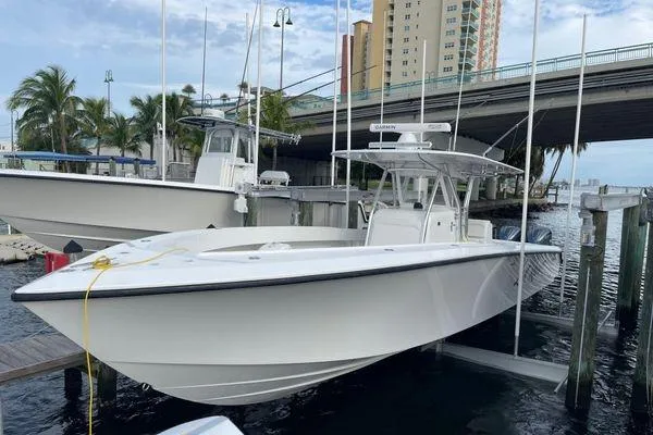Last Resort Yacht Photos Pics 2013 Bahama 41 Open Fisherman boat docked near a bridge, with palm trees in the background.