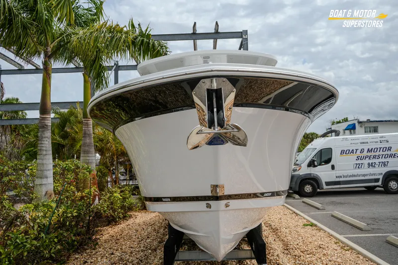  Yacht Photos Pics 2026 Blackfin 272 DC boat displayed at dealership with palm trees and van in background.