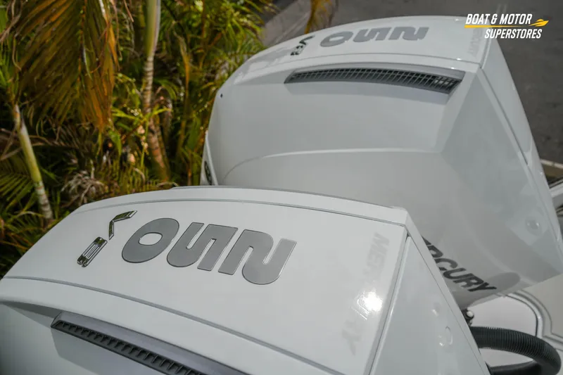  Yacht Photos Pics Twin Mercury outboard engines on a 2026 Blackfin 272 DC boat, with tropical foliage background.