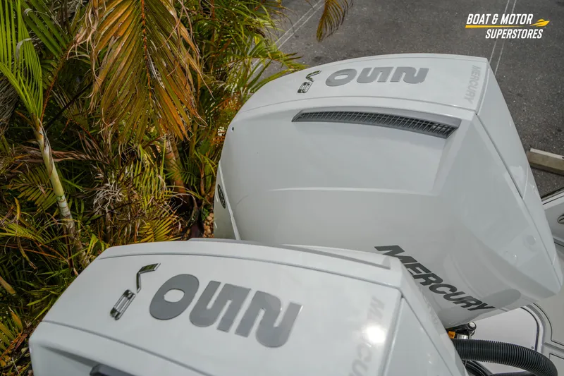  Yacht Photos Pics Twin Mercury outboard engines on a 2026 Blackfin 272 DC boat near tropical foliage.