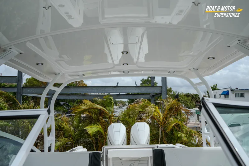  Yacht Photos Pics 2026 Blackfin 272 DC boat interior with canopy and twin engines, surrounded by palm trees.