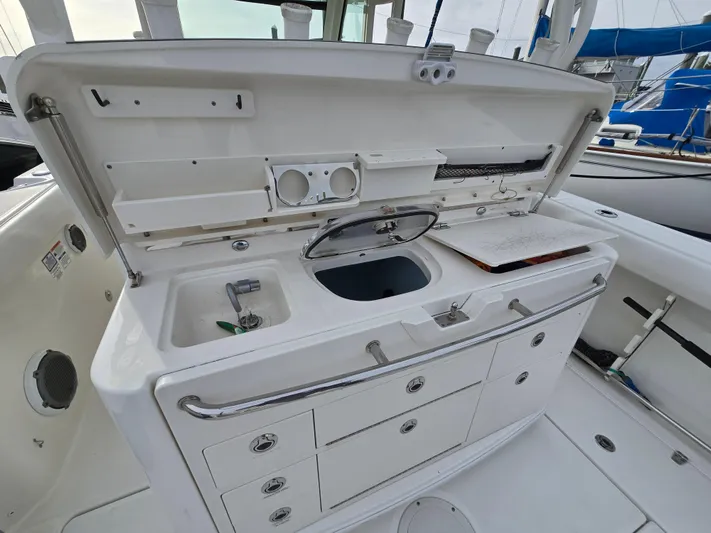  Yacht Photos Pics 2015 Boston Whaler 350 Outrage boat galley with sink, storage, and preparation area.