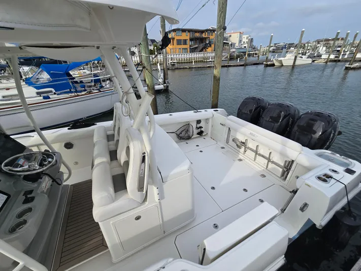  Yacht Photos Pics 2015 Boston Whaler 350 Outrage boat docked, featuring spacious deck and triple outboard engines.