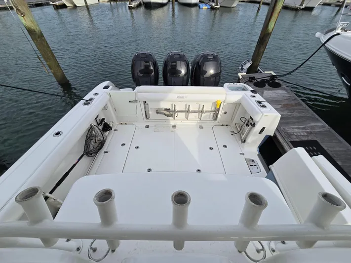  Yacht Photos Pics 2015 Boston Whaler 350 Outrage boat docked, featuring spacious deck and triple outboard engines.