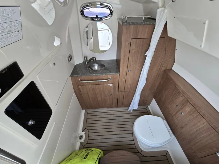  Yacht Photos Pics 2015 Boston Whaler 350 Outrage cabin interior with sink, toilet, and wood cabinetry.