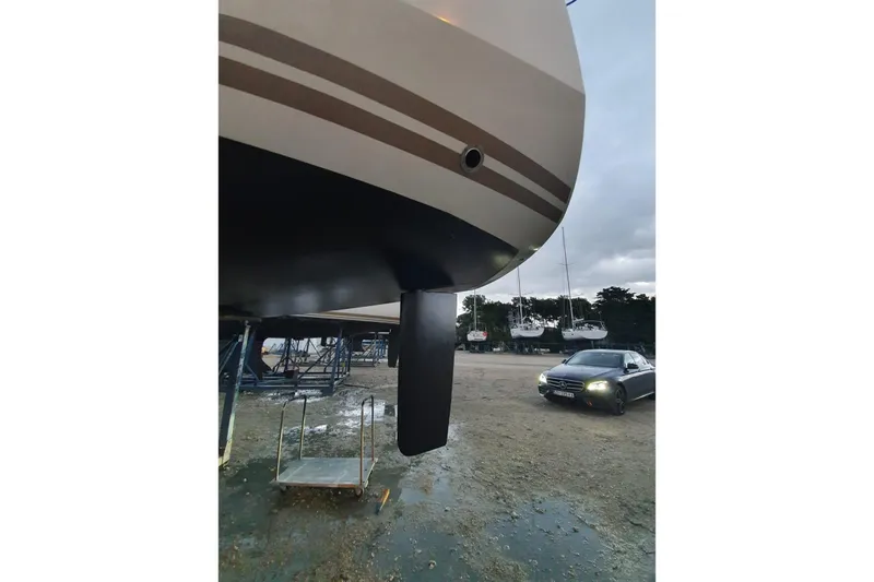  Yacht Photos Pics 2013 Jeanneau Sun Odyssey 409 sailboat on land with car nearby.