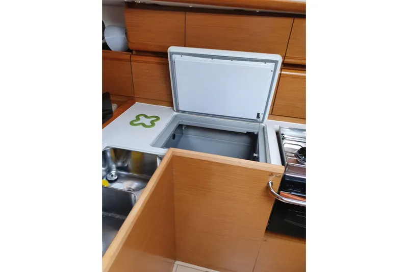  Yacht Photos Pics Interior of 2013 Jeanneau Sun Odyssey 409 yacht kitchen with open fridge and sink.