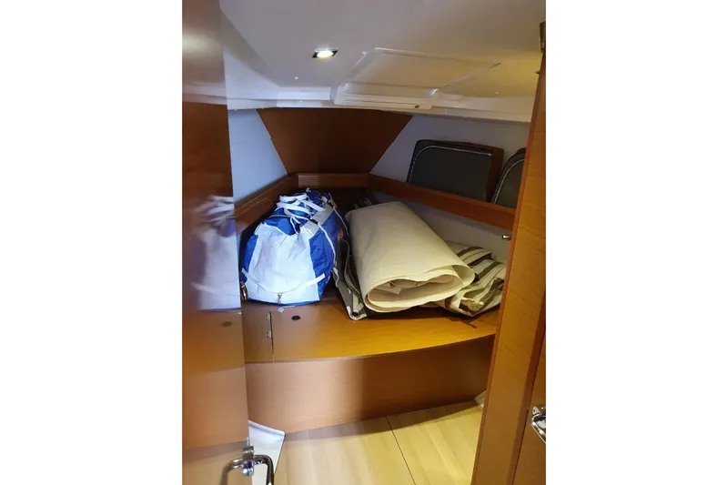  Yacht Photos Pics Storage area inside 2013 Jeanneau Sun Odyssey 409 yacht with bags and rolled linens.