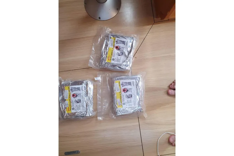  Yacht Photos Pics Three vacuum-sealed emergency kits on a wooden floor of a 2013 Jeanneau Sun Odyssey 409.