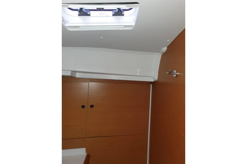  Yacht Photos Pics Interior cabin of 2013 Jeanneau Sun Odyssey 409 sailboat, featuring wooden paneling and ceiling hatch.