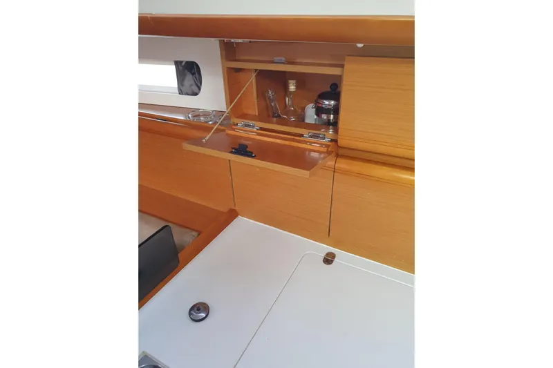  Yacht Photos Pics Interior of 2013 Jeanneau Sun Odyssey 409 sailboat, featuring wooden cabinetry and storage.