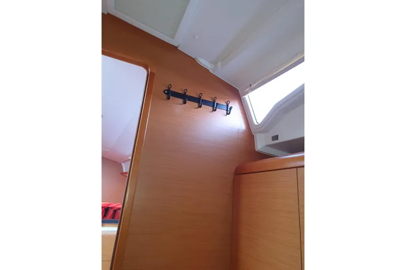  Yacht Photos Pics Interior of 2013 Jeanneau Sun Odyssey 409 sailboat with wooden paneling and coat hooks.