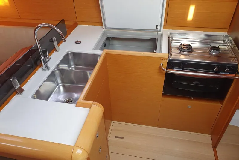  Yacht Photos Pics Modern kitchen in 2013 Jeanneau Sun Odyssey 409 yacht with sink, stove, and storage.