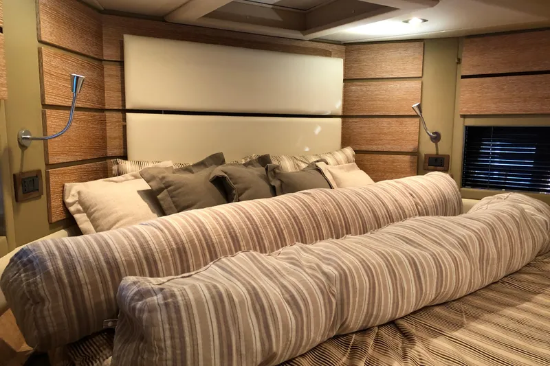  Yacht Photos Pics Luxurious bedroom interior of 2014 Azimut Fly 60 yacht with striped bedding and modern lighting.