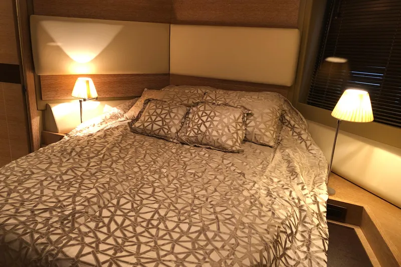  Yacht Photos Pics Luxurious bedroom interior on a 2014 Azimut Fly 60 yacht, featuring elegant bedding and warm lighting.