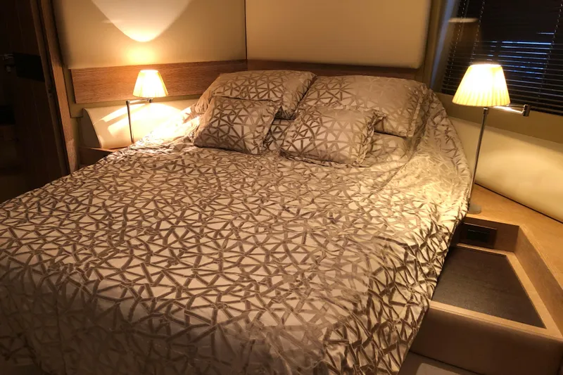  Yacht Photos Pics Luxurious bedroom interior on a 2014 Azimut Fly 60 yacht, featuring elegant bedding and warm lighting.